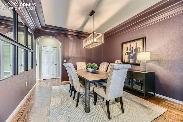 dining area with hardwood / wood-style flooring and crown molding