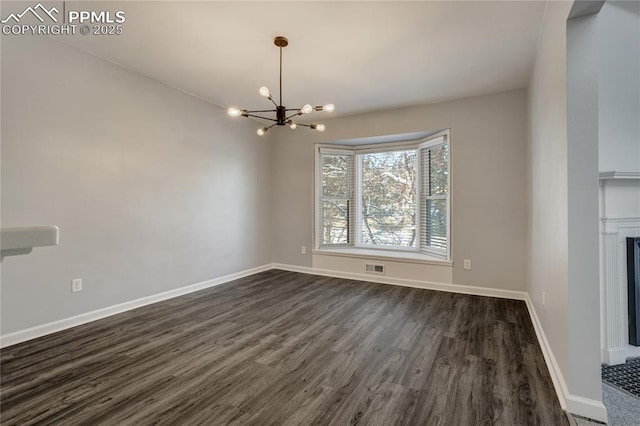 unfurnished dining area with dark hardwood / wood-style floors and an inviting chandelier