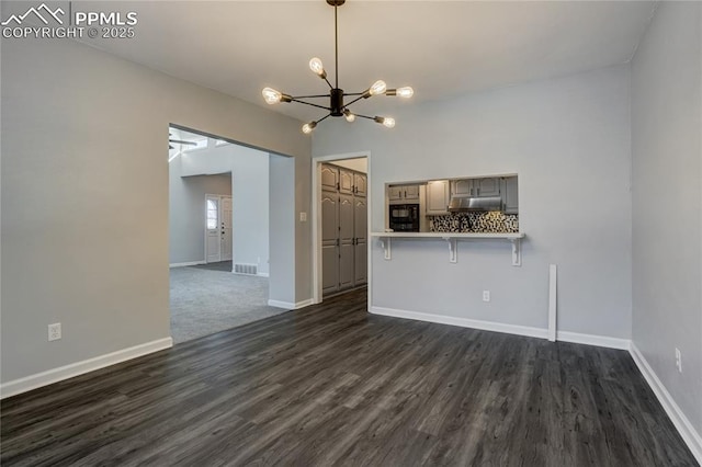 unfurnished living room featuring dark wood-type flooring and a chandelier