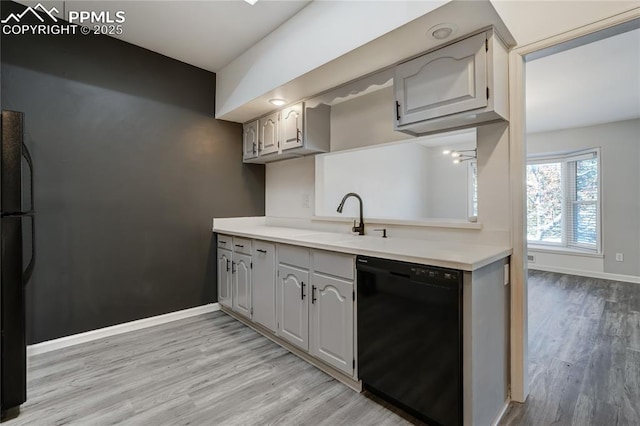 kitchen featuring black appliances, gray cabinetry, light wood-type flooring, and sink