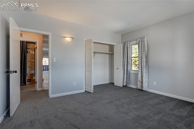 unfurnished bedroom with dark carpet and a closet