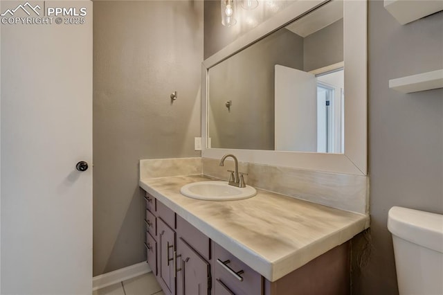 bathroom with tile patterned flooring, vanity, and toilet