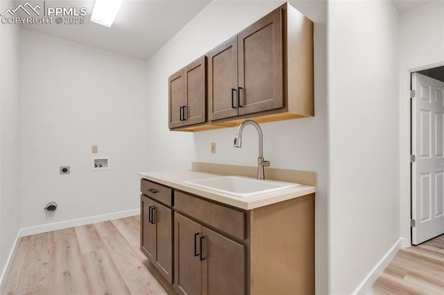 laundry area with electric dryer hookup, cabinets, sink, washer hookup, and light hardwood / wood-style floors