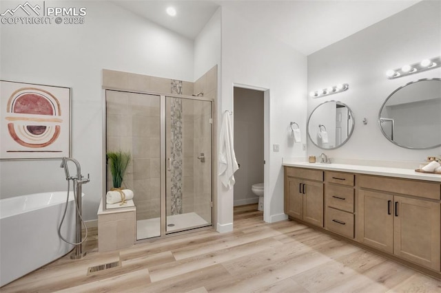 full bathroom featuring toilet, hardwood / wood-style floors, vanity, and shower with separate bathtub