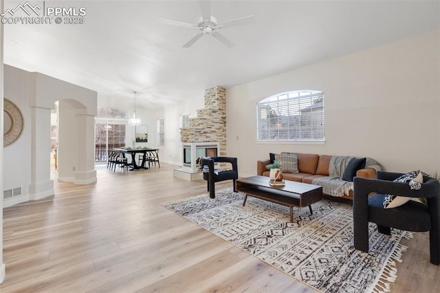 living room with ceiling fan, a fireplace, and light hardwood / wood-style floors