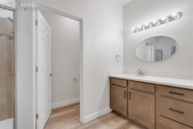 bathroom featuring hardwood / wood-style floors, vanity, and a shower with shower door