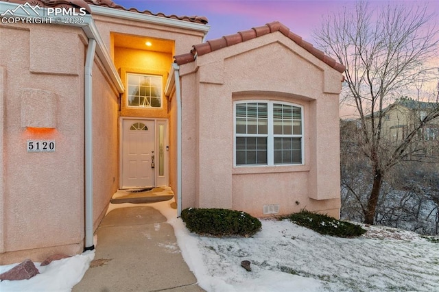 view of snow covered property entrance