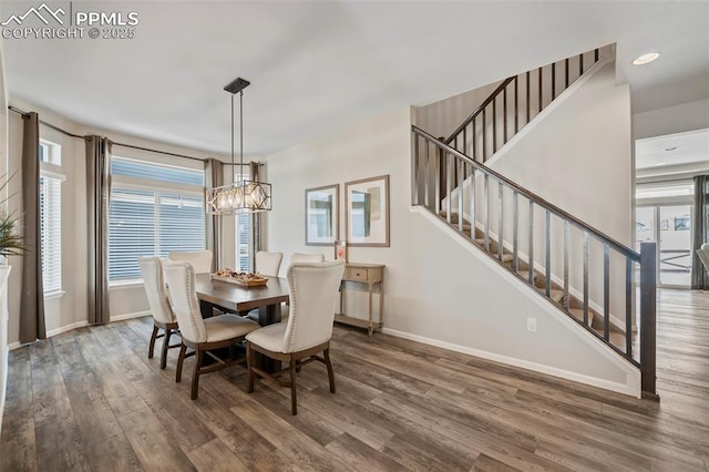 dining area featuring dark wood-type flooring and an inviting chandelier