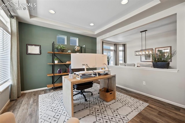 home office featuring hardwood / wood-style floors and a raised ceiling