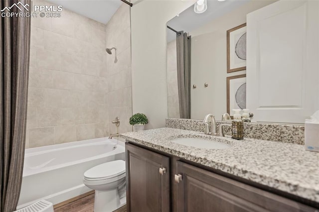 full bathroom with hardwood / wood-style flooring, toilet, vanity, and tiled shower / bath