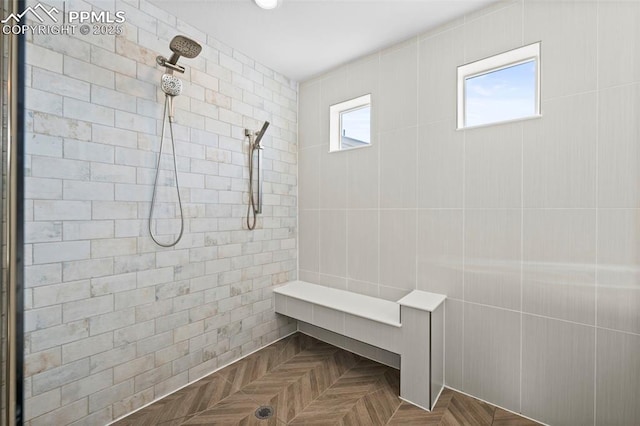 bathroom featuring a wealth of natural light, a tile shower, and parquet flooring