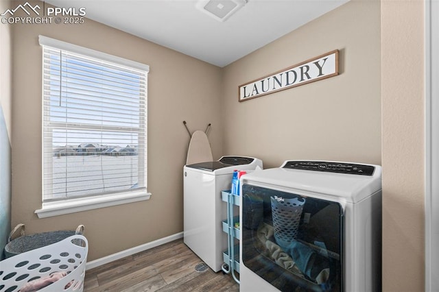 clothes washing area featuring wood-type flooring and washer and dryer