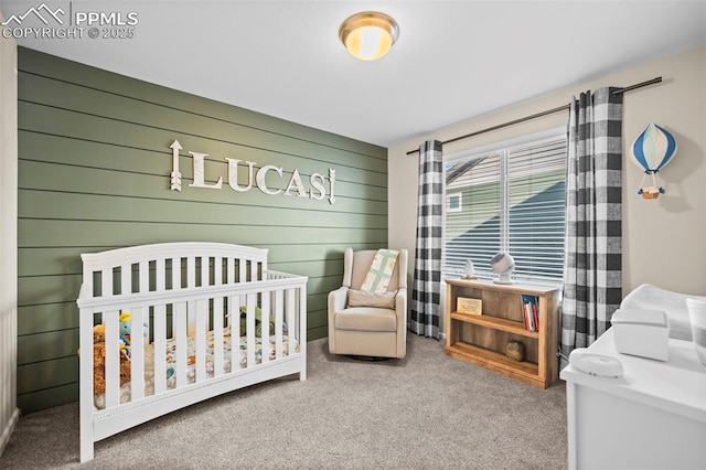 bedroom with a nursery area, wood walls, and carpet flooring