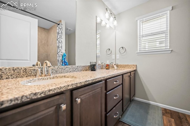 bathroom with curtained shower, hardwood / wood-style floors, and vanity