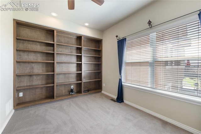 unfurnished room featuring ceiling fan, a healthy amount of sunlight, and light carpet