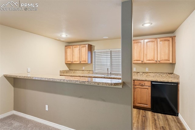 kitchen featuring light brown cabinetry, black dishwasher, carpet floors, and light stone counters