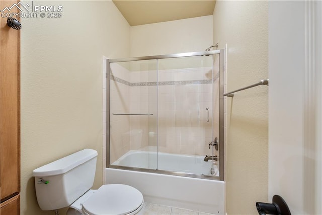 bathroom with enclosed tub / shower combo and toilet