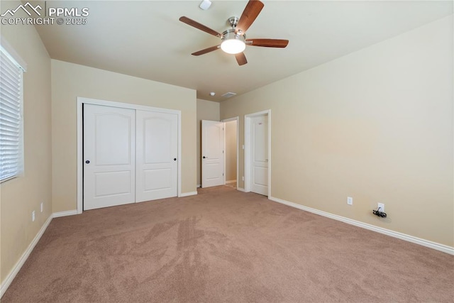 unfurnished bedroom with ceiling fan, light colored carpet, and a closet