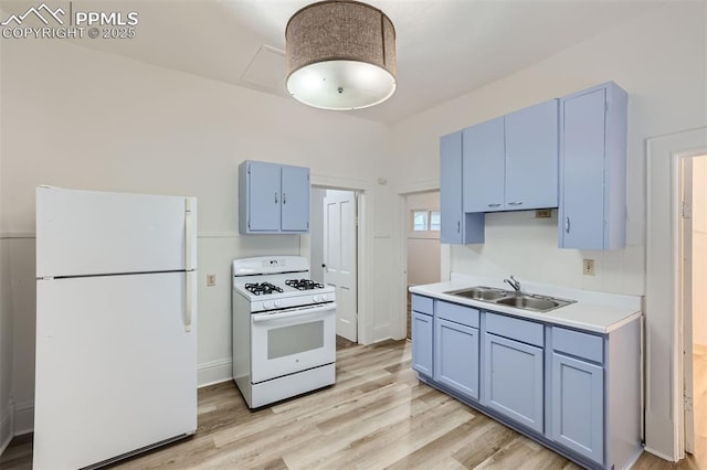 kitchen featuring light wood-type flooring, white appliances, sink, and blue cabinets