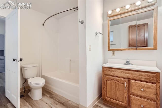 full bathroom featuring washtub / shower combination, hardwood / wood-style floors, vanity, and toilet