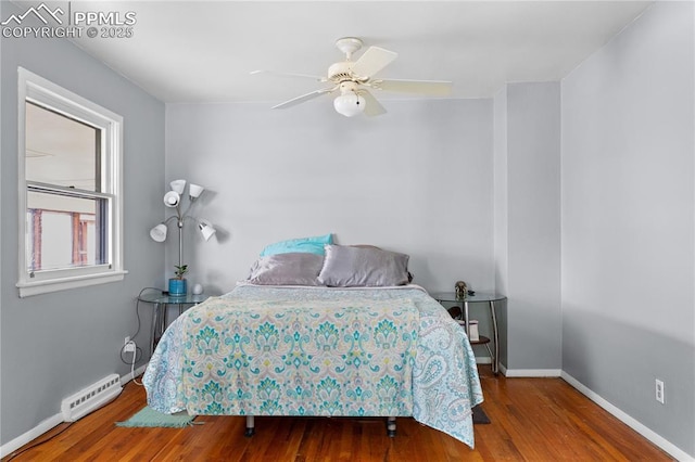 bedroom featuring ceiling fan, a baseboard heating unit, and hardwood / wood-style flooring