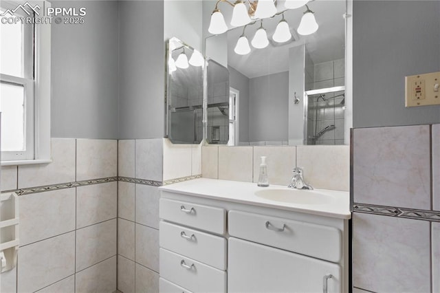 bathroom featuring vanity, tile walls, and walk in shower
