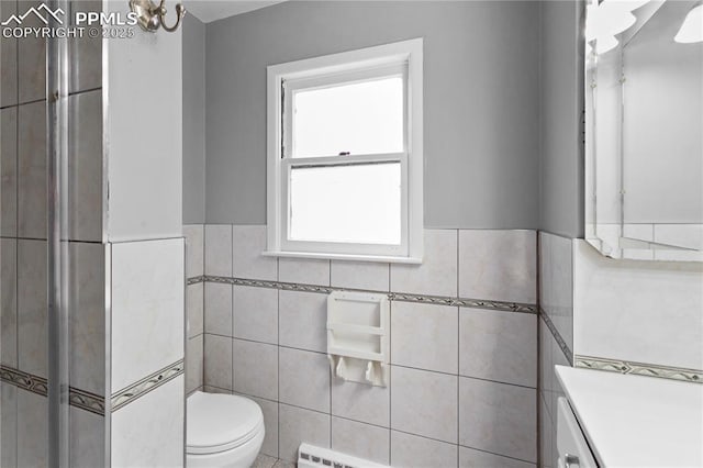 bathroom with vanity, toilet, and tile walls