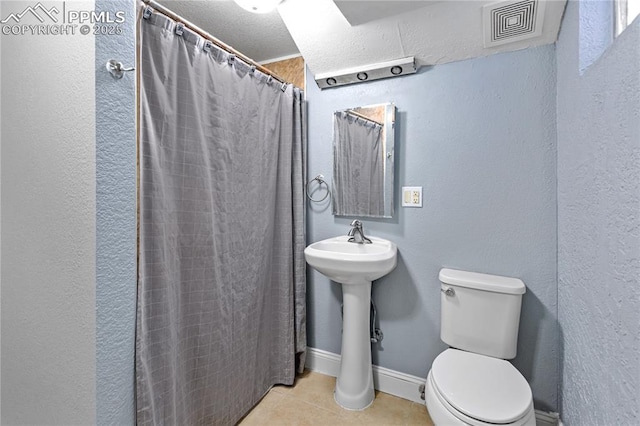 bathroom with tile patterned flooring, toilet, and a shower with shower curtain
