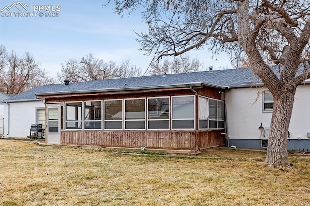 rear view of property with a sunroom and a lawn