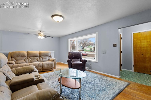 living room with ceiling fan, wood-type flooring, and a textured ceiling