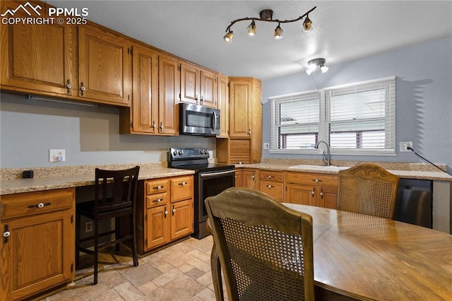kitchen featuring light stone counters, sink, and black range with electric cooktop