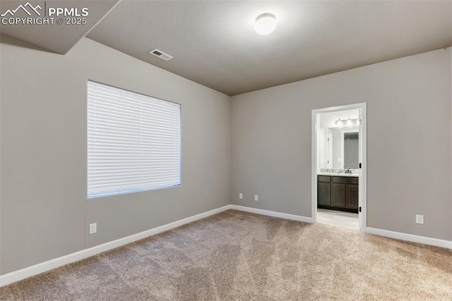 unfurnished room with sink and light carpet