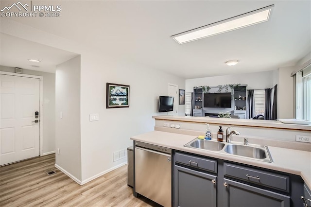 kitchen featuring dishwasher, gray cabinets, light hardwood / wood-style flooring, and sink