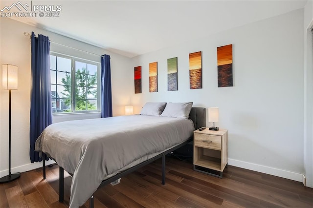 bedroom with dark hardwood / wood-style flooring