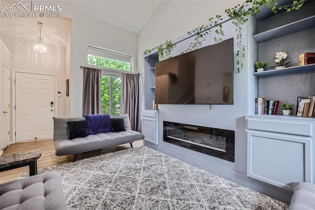 living room with a notable chandelier and vaulted ceiling