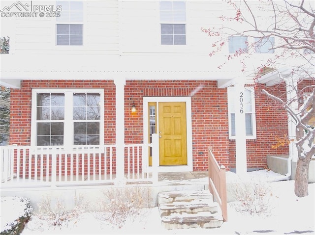 view of snow covered property entrance