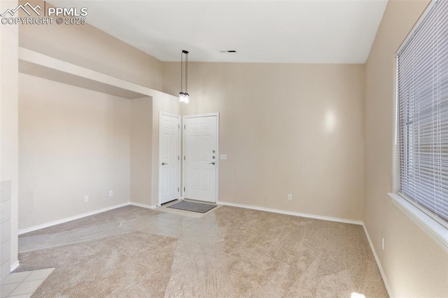 carpeted empty room featuring high vaulted ceiling