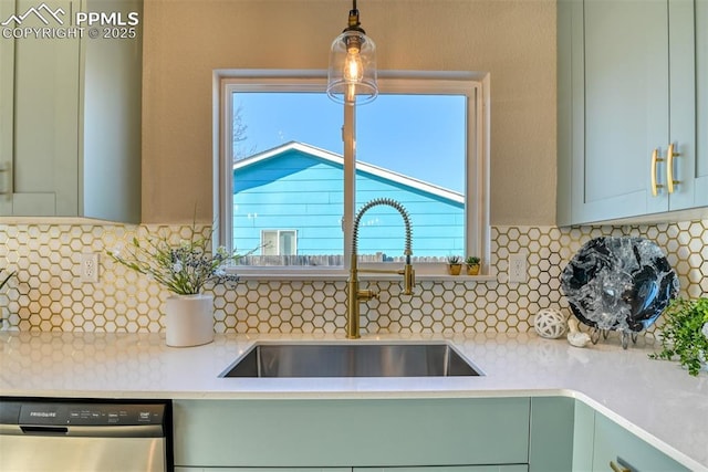 kitchen featuring sink, decorative backsplash, dishwasher, and hanging light fixtures