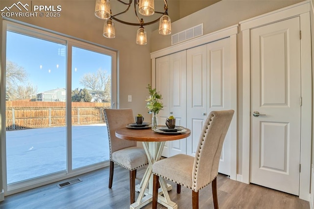 dining area featuring an inviting chandelier and hardwood / wood-style flooring