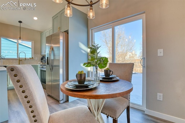 dining area with light hardwood / wood-style floors, a wealth of natural light, and sink