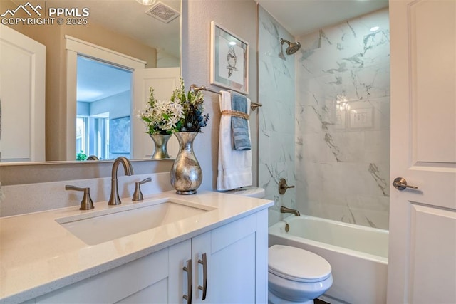 full bathroom with toilet, vanity, and tiled shower / bath