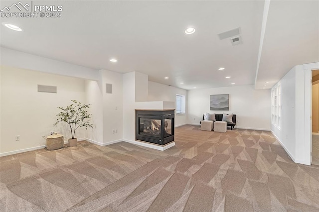 unfurnished living room featuring a multi sided fireplace and light colored carpet