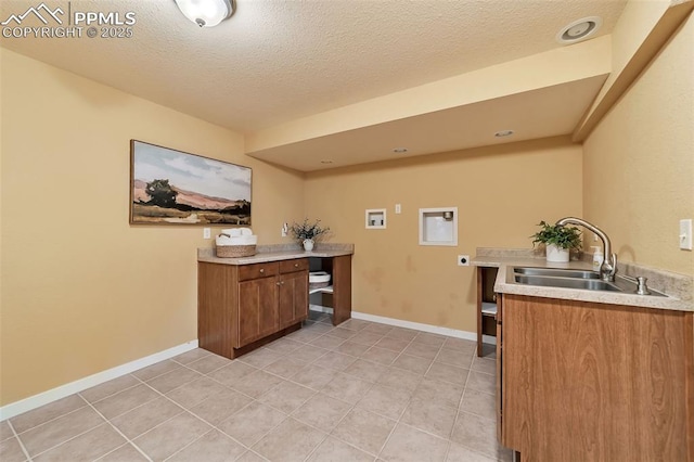 laundry room featuring sink, washer hookup, hookup for an electric dryer, a textured ceiling, and light tile patterned floors