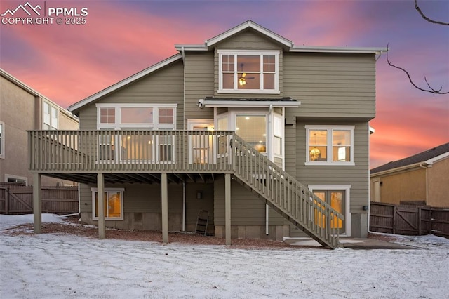 snow covered rear of property featuring a deck