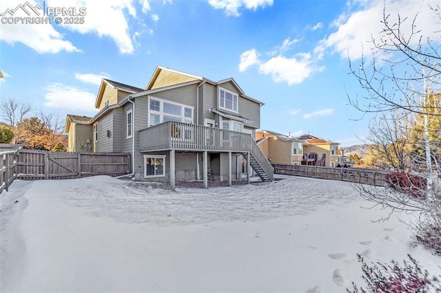 snow covered back of property featuring a wooden deck