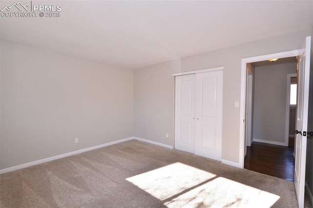 unfurnished bedroom with a closet and dark colored carpet