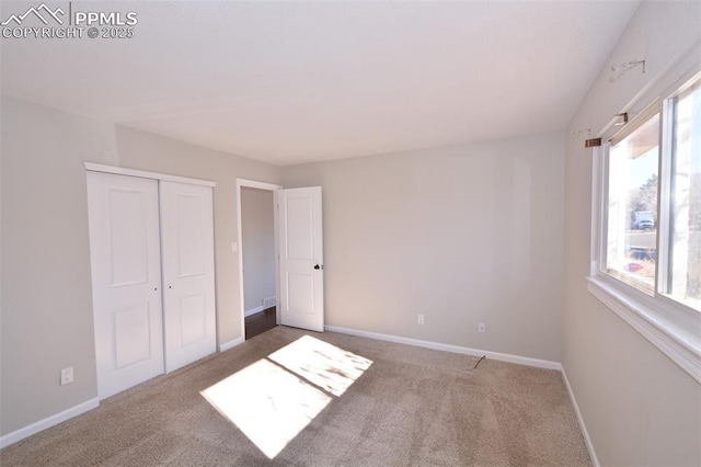 unfurnished bedroom with multiple windows, a closet, and carpet floors