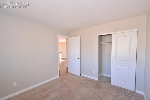 unfurnished bedroom featuring light colored carpet and a closet