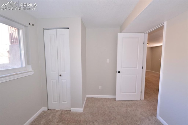 unfurnished bedroom featuring a closet, light carpet, and multiple windows