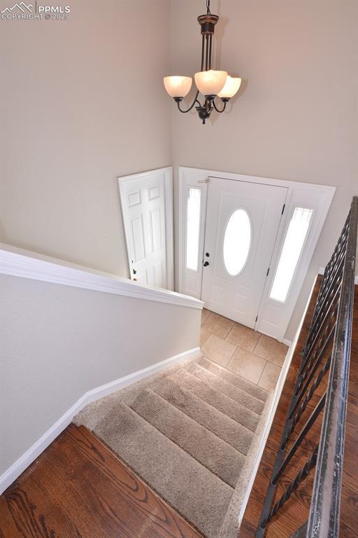 foyer entrance with tile patterned flooring and a chandelier